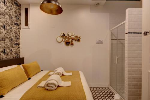 une chambre avec un lit avec deux poupées dessus dans l'établissement LE COCOON 29 by Cocoonr, à Bordeaux