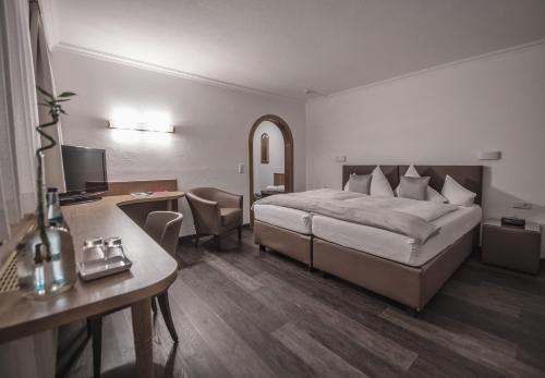 a hotel room with a bed and a desk at Hotel Maria Theresia in Mayrhofen