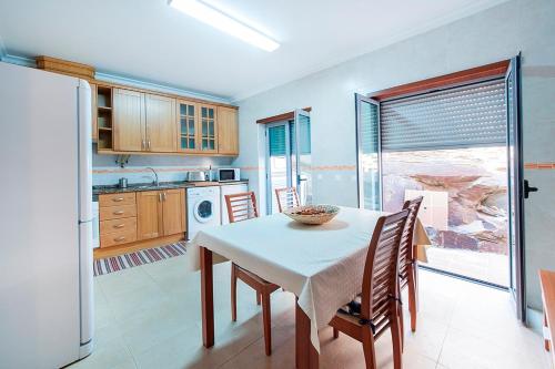 a kitchen with a table and chairs and a kitchen with a window at Turismo Guadiana - Casas in Mértola