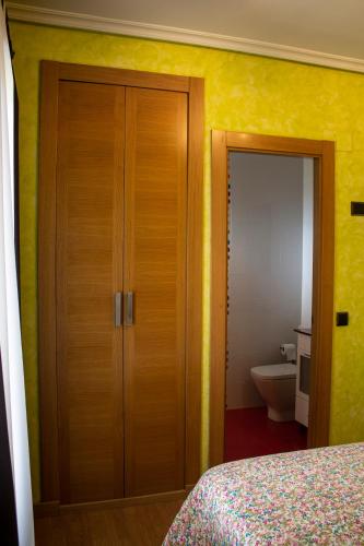 a bedroom with a wooden closet and a toilet at La Cueva del Tempranillo in Huércanos