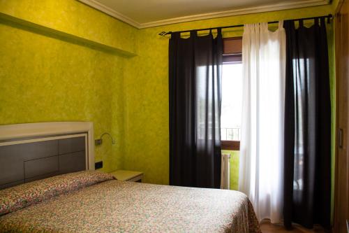 a bedroom with a bed and a window at La Cueva del Tempranillo in Huércanos