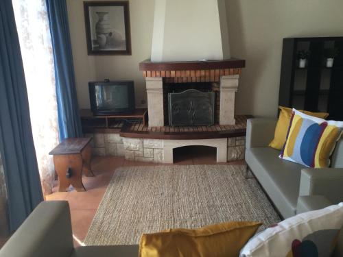 a living room with a fireplace and a couch at Turismo Guadiana - Casas in Mértola