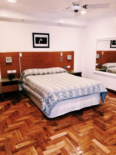 a bedroom with a large bed and a wooden floor at Hotel Petit Cordoba in Córdoba
