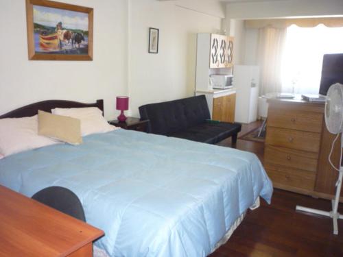 1 dormitorio con cama, escritorio y silla en Rodeo Departamentos Amoblados en Rancagua