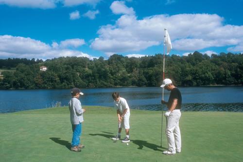 a group of three people standing on a golf course at Hôtel Angelic in Lourdes