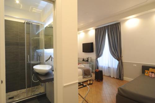 un bagno con lavandino e un letto in una camera di My Suites Piazza di Spagna a Roma