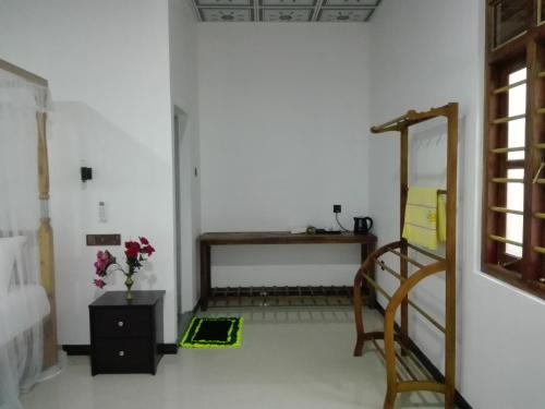 a room with a mirror and a table and a desk at Calm Garden Cabanas in Tangalle
