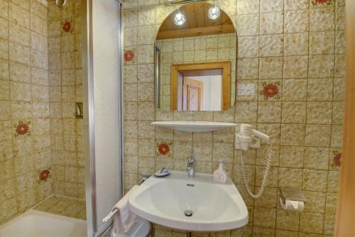 a bathroom with a sink and a mirror at Hotel Wechselberger by Alpeffect Hotels in Saalbach Hinterglemm