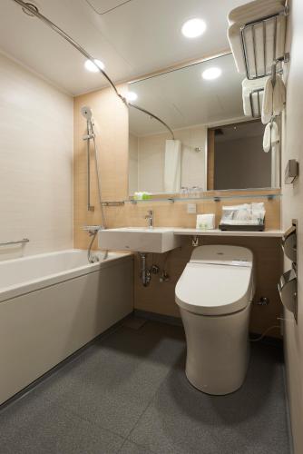 a bathroom with a toilet and a sink and a tub at HOTEL 1899 TOKYO in Tokyo