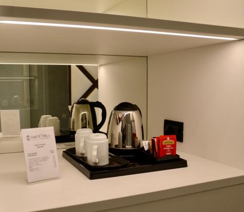 a counter with a tray with a tea kettle and cups at Hotel Victoria in Vicenza