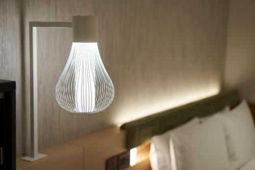 a light fixture hanging from a wall in a bathroom at HOTEL 1899 TOKYO in Tokyo