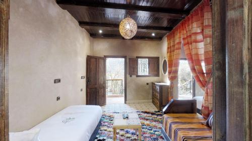 a bedroom with a bed and a couch in a room at ferme by Ikalimo in Ourika