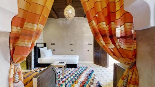 a bedroom with a bed and a window with curtains at ferme by Ikalimo in Ourika