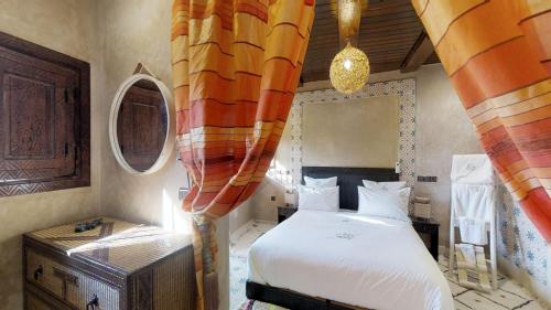 a bedroom with a bed in a room with curtains at ferme by Ikalimo in Ourika