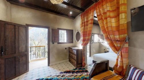 a bedroom with a bed and a window and a desk at ferme by Ikalimo in Ourika