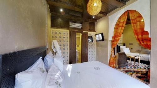 a bedroom with a bed and a room with a bedroomictericter at ferme by Ikalimo in Ourika