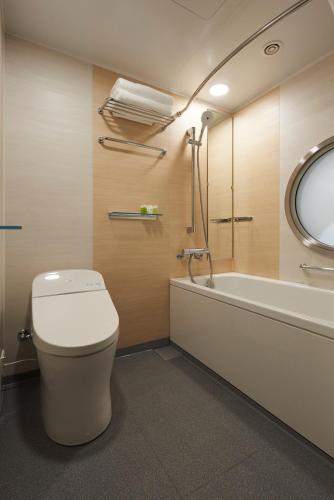 a bathroom with a toilet and a bath tub at HOTEL 1899 TOKYO in Tokyo