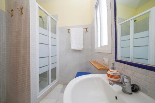 bagno bianco con lavandino e specchio di AlohaMundi Valvanera a Siviglia