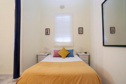 una camera con un letto con una coperta gialla di AlohaMundi Valvanera a Siviglia