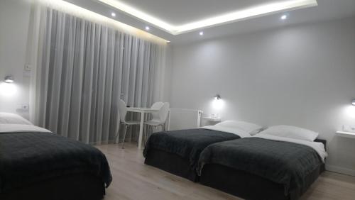 a hotel room with two beds and a table at Perłowa Przystań in Pierwoszyno