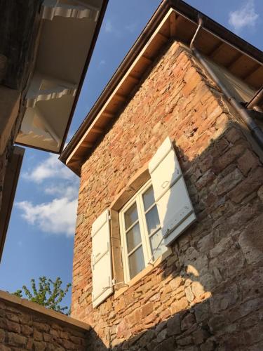 a window on the side of a brick building at Chambres d'hôtes Vers la Croix in Leynes