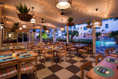 a restaurant with tables and chairs and lights at The Plymouth South Beach in Miami Beach