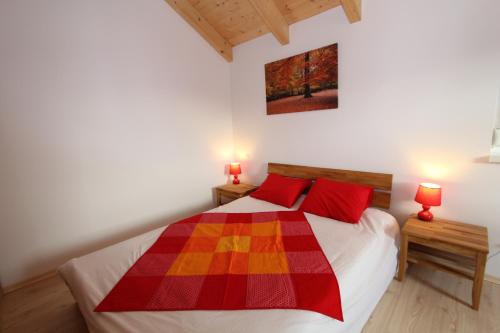 a bedroom with a bed with red pillows at Chalet Underhill in Kötschach