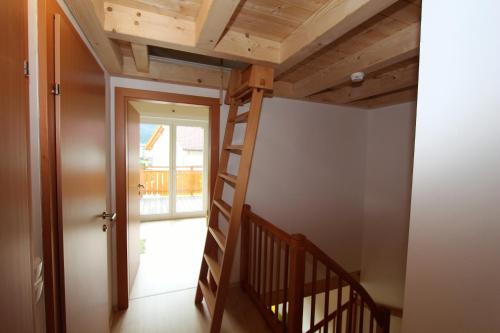 a staircase leading up to a room with wooden ceilings at Chalet Underhill in Kötschach
