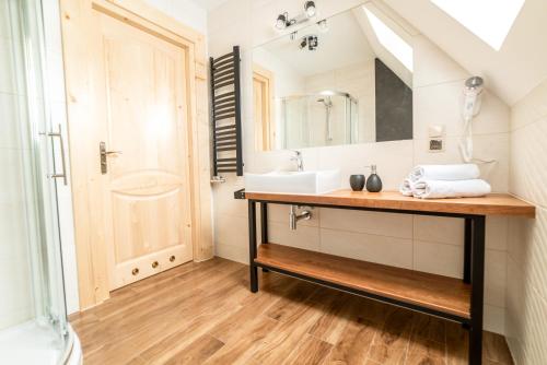 a bathroom with a sink and a mirror at Apartamenty Augustynówka in Brzegi