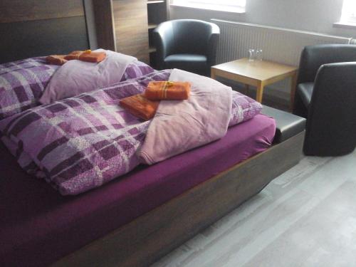 a bed with a purple comforter in a room at JaNettes Gästehaus in Bad Doberan