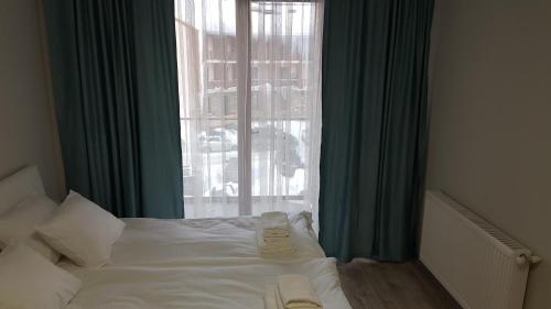 a bedroom with a white bed with a window at New Gudauri, Loft 1 in Gudauri