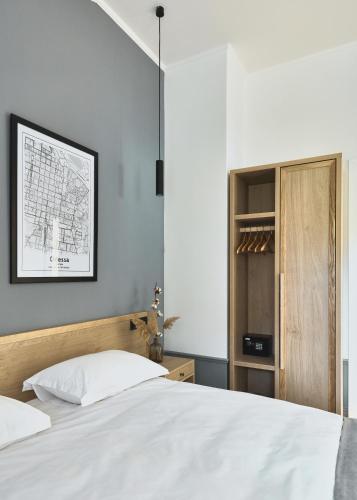 a bedroom with a white bed with a wooden headboard at Wine&Pillow Hotel by Frapolli in Odesa
