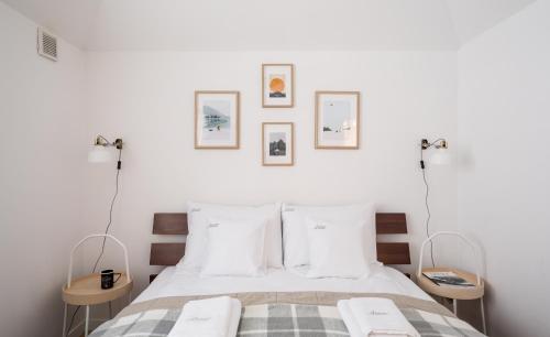 ザコパネにあるZAKOHOME- Apartament Skoczniaの白い壁のベッドルーム1室、ベッド1台(白い枕付)