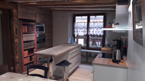 a small kitchen with a counter and a window at Au fil de l'écriture - Appartement sur la Route des Vins à riquewihr in Riquewihr