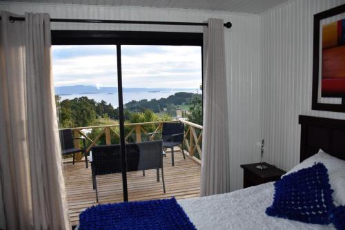 a bedroom with a bed and a view of a deck at La Casita Amarilla in Futrono