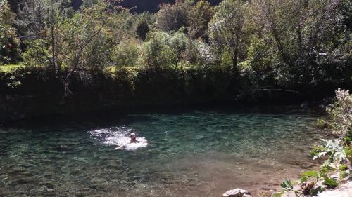 a person swimming in a body of water at La Frontera Bed & Breakfast, Valle Cochamó in Cochamó