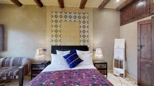 a bedroom with a large bed with blue pillows at ferme by Ikalimo in Ourika