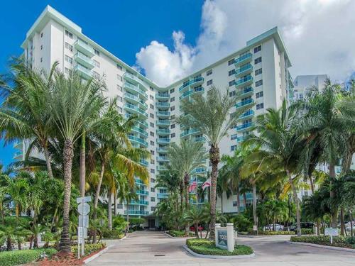 a large building with palm trees in front of it at Miami Hallandale Condo, Partial Ocean View Direct Beach and Pool Access Miami Hollywood Beach in Hollywood