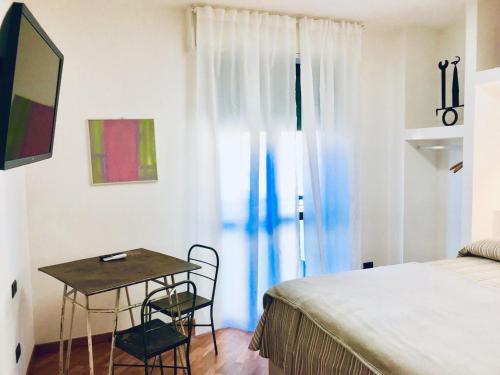 a bedroom with a bed and a table with two chairs at Camere Delle Rose in Milan