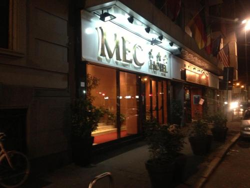 a mex sign on a store front at night at Hotel Mec in Milan