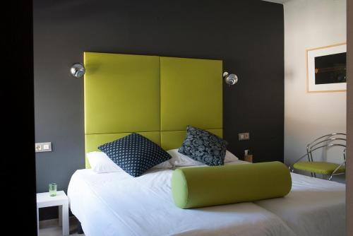 a bedroom with a bed with a green headboard at Hostal Totsompops in Colera