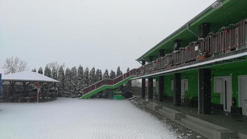 a snow covered courtyard of a building with a snow covered yard at Apartman Taktik in Veľký Meder