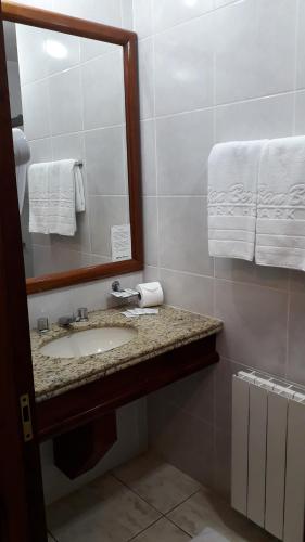 a bathroom with a sink and a mirror and towels at San Bernardo Park Hotel in Vacaria