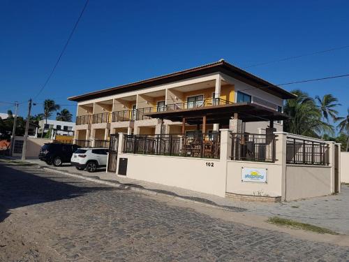 un gran edificio con balcón en una calle en Sol e Mar - AP 05 - Be Summer en Flecheiras