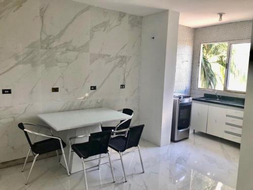 a kitchen with a table and chairs and a marble wall at Apartamento no Edifício Florida Terrace in Matinhos