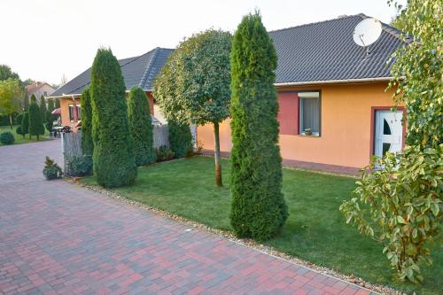 a row of trees in front of a house at Homokháti Apartman in Mórahalom