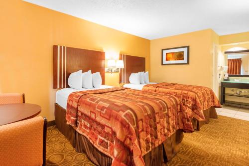 a hotel room with two beds and a chair at Motel 6-Little Rock, AR - Airport in Little Rock