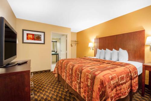 ein Hotelzimmer mit einem Bett und einem Flachbild-TV in der Unterkunft Motel 6-Little Rock, AR - Airport in Little Rock