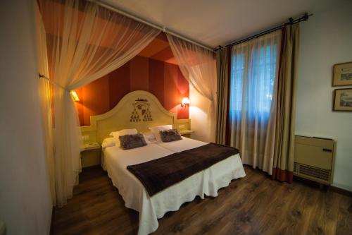 a bedroom with a bed and a large window at Hotel Hacienda del Cardenal in Toledo