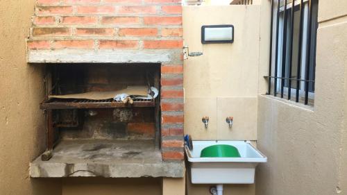 un lavabo en una pared de ladrillo junto a un edificio en Alojamiento Monte Hermoso en Monte Hermoso